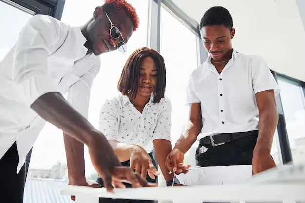 standing-by-table-planning-project-group-african-american-business-people-working-office-together_146671-43679